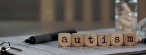 Blocks spelling out autism on top of a notepad