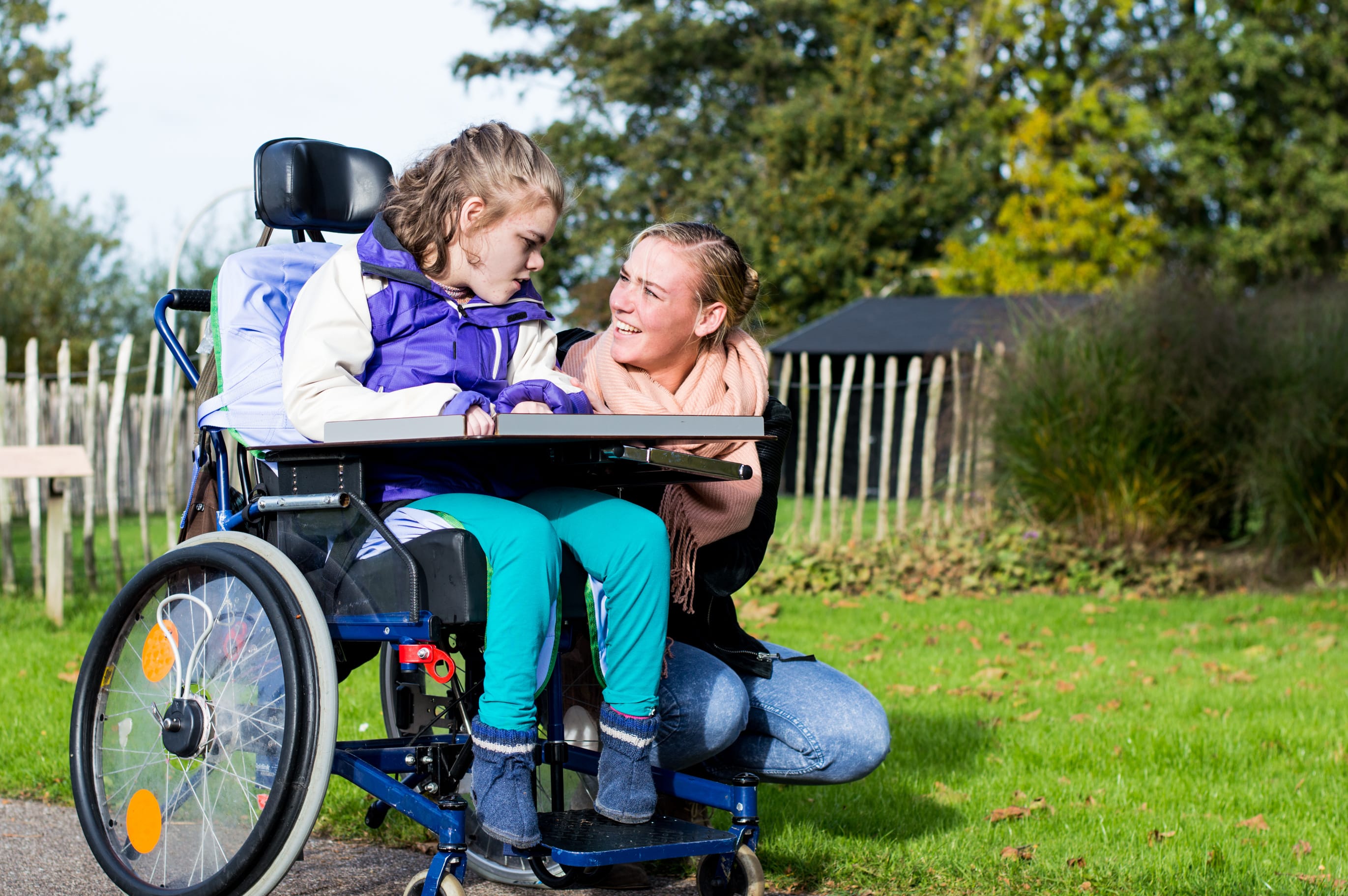 Disabled child with her carer in a park
